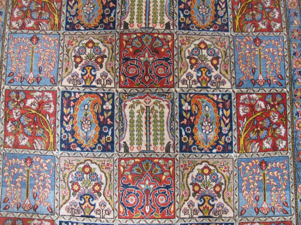 A rectangular hand-knotted Persian Qum rug featuring a central field of grid compartments filled with botanical and cypress motifs framed by a red border. View VII