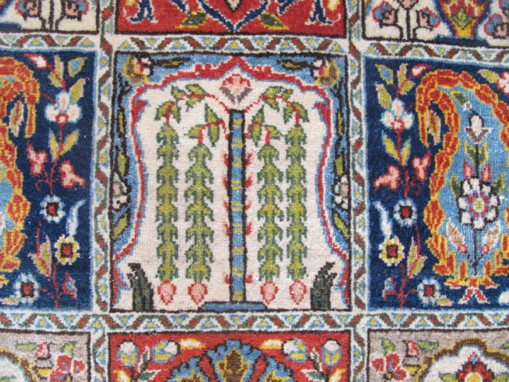 A rectangular hand-knotted Persian Qum rug featuring a central field of grid compartments filled with botanical and cypress motifs framed by a red border. View VIII