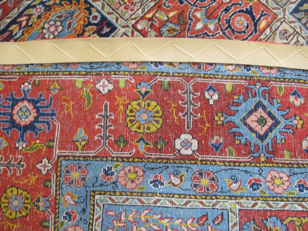 A rectangular hand-knotted Persian Qum rug featuring a central field of grid compartments filled with botanical and cypress motifs framed by a red border. View XIII