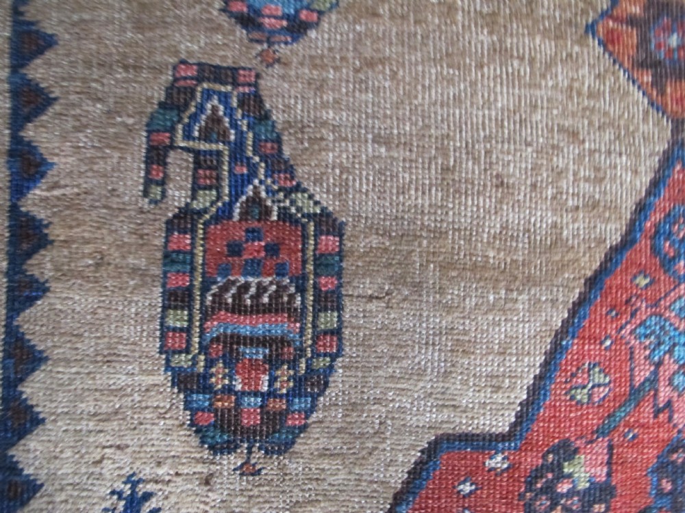An antique hand-knotted wool long rug featuring a central red diamond medallion on a camel field framed by blue spandrels and multi-banded borders. View XII