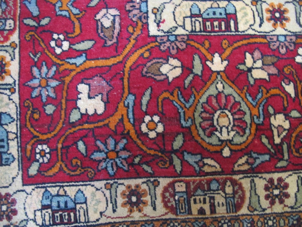 An antique Persian Isfahan hand-knotted wool rug featuring a light blue field with a vase and floral tree motif flanked by deer, framed by a red floral border. View IV