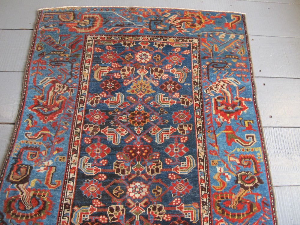 A late 19th-century hand-knotted Persian Hamadan wool rug featuring a dark navy central field surrounded by vibrant blue and red borders with intricate geometric floral motifs. View XI