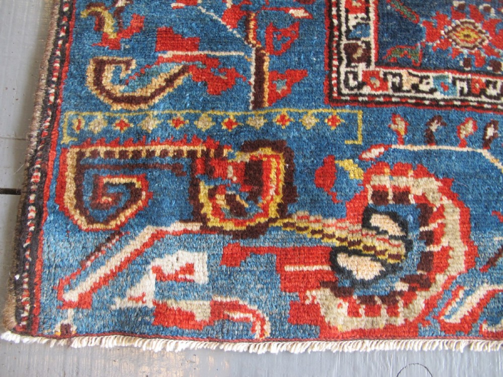 A late 19th-century hand-knotted Persian Hamadan wool rug featuring a dark navy central field surrounded by vibrant blue and red borders with intricate geometric floral motifs. View XVI