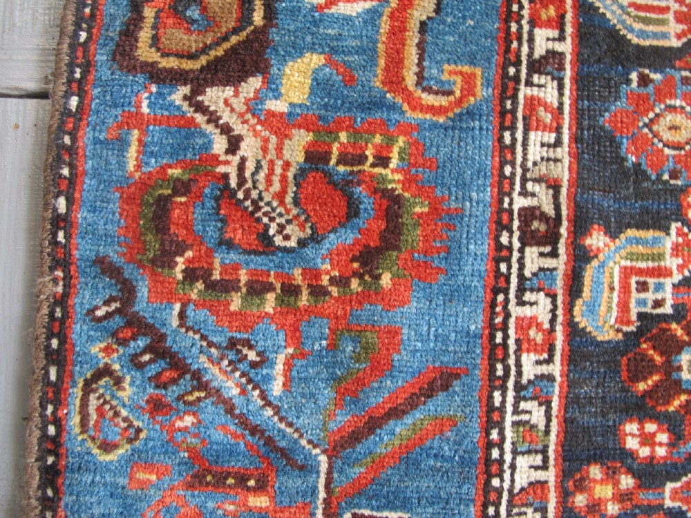 A late 19th-century hand-knotted Persian Hamadan wool rug featuring a dark navy central field surrounded by vibrant blue and red borders with intricate geometric floral motifs. View XX