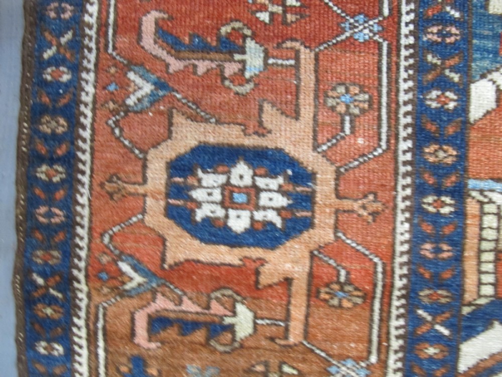 A large 19th-century antique Persian Serapi wool carpet featuring a bold geometric central medallion in navy blue and terracotta on an ivory field with wide decorative borders. View VII
