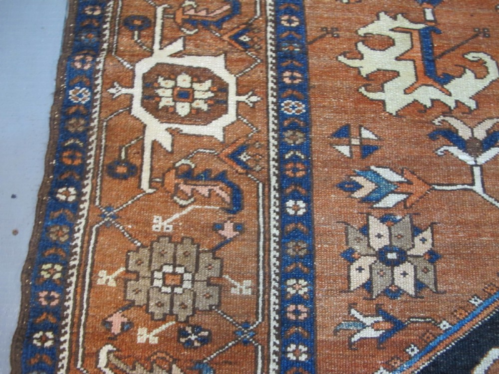 A large 19th-century antique Persian Serapi wool carpet featuring a bold geometric central medallion in navy blue and terracotta on an ivory field with wide decorative borders. View IX