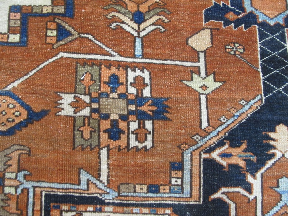 A large 19th-century antique Persian Serapi wool carpet featuring a bold geometric central medallion in navy blue and terracotta on an ivory field with wide decorative borders. View XI