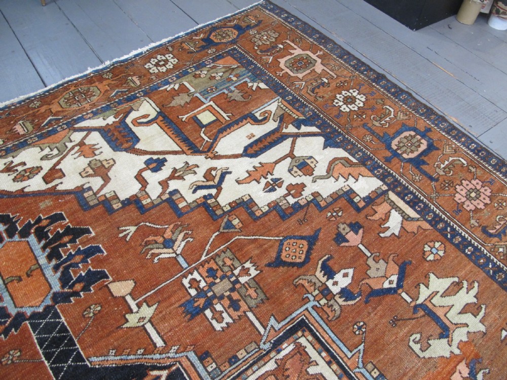 A large 19th-century antique Persian Serapi wool carpet featuring a bold geometric central medallion in navy blue and terracotta on an ivory field with wide decorative borders. View XII