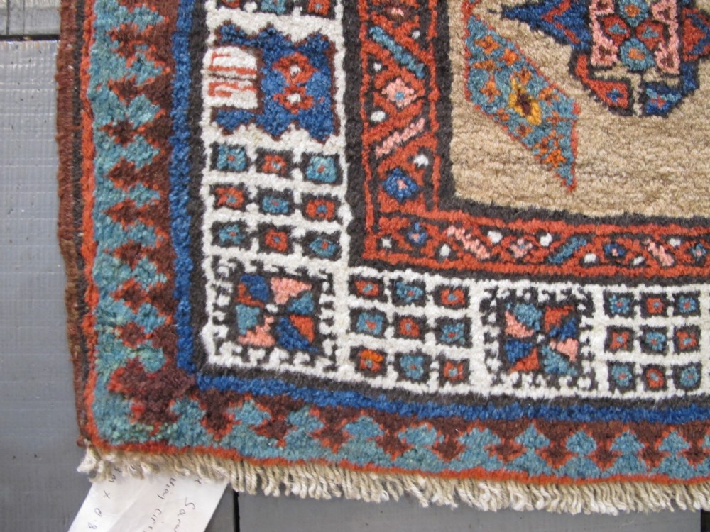 A long and narrow North-West Persian wool runner rug featuring repeating geometric diamond medallions in terracotta, beige, and navy hues. View III