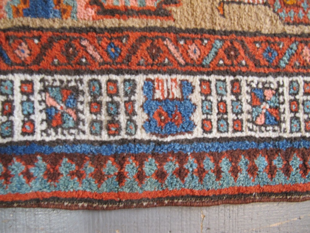A long and narrow North-West Persian wool runner rug featuring repeating geometric diamond medallions in terracotta, beige, and navy hues. View VII