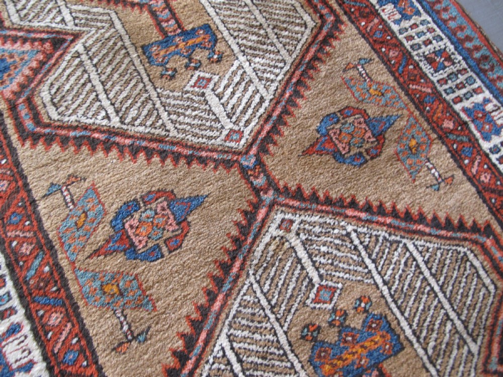 A long and narrow North-West Persian wool runner rug featuring repeating geometric diamond medallions in terracotta, beige, and navy hues. View VIII