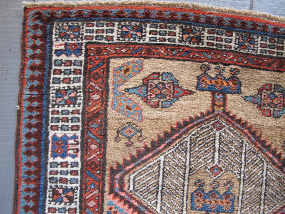 A long and narrow North-West Persian wool runner rug featuring repeating geometric diamond medallions in terracotta, beige, and navy hues. View X