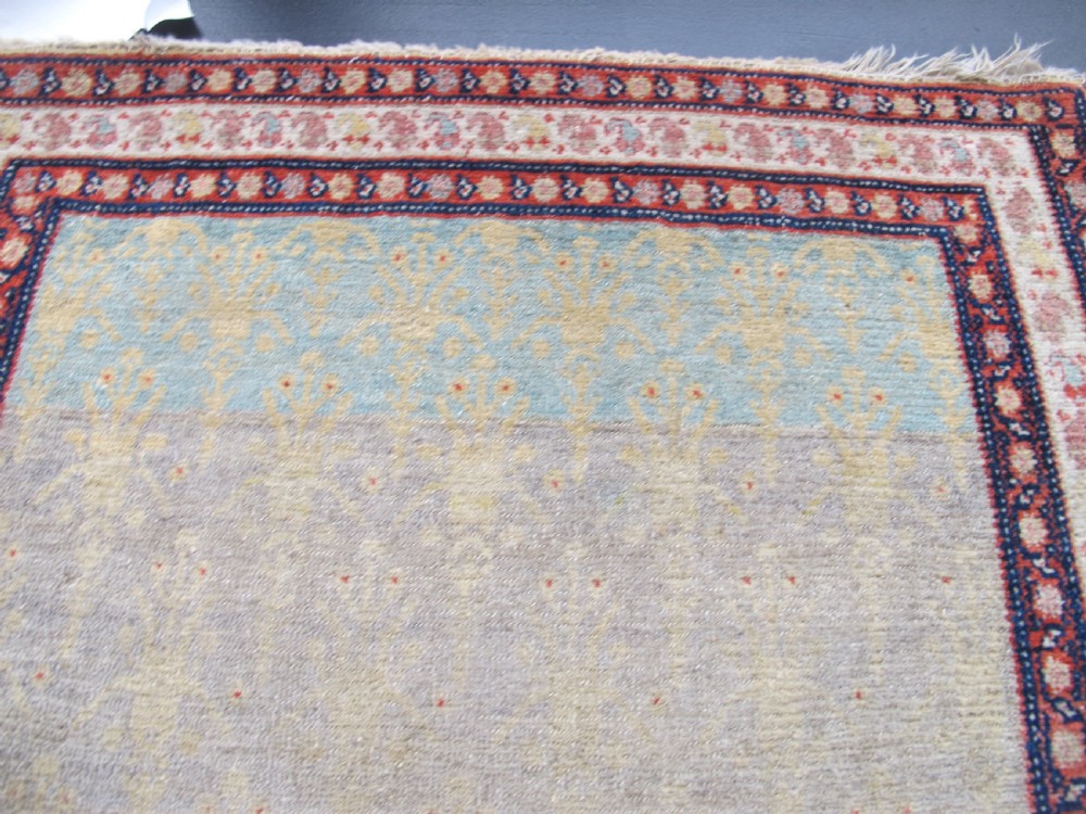 A pair of late nineteenth-century Persian Senneh hand-knotted wool rugs featuring pale cream central fields and multi-stripe red borders. View VII