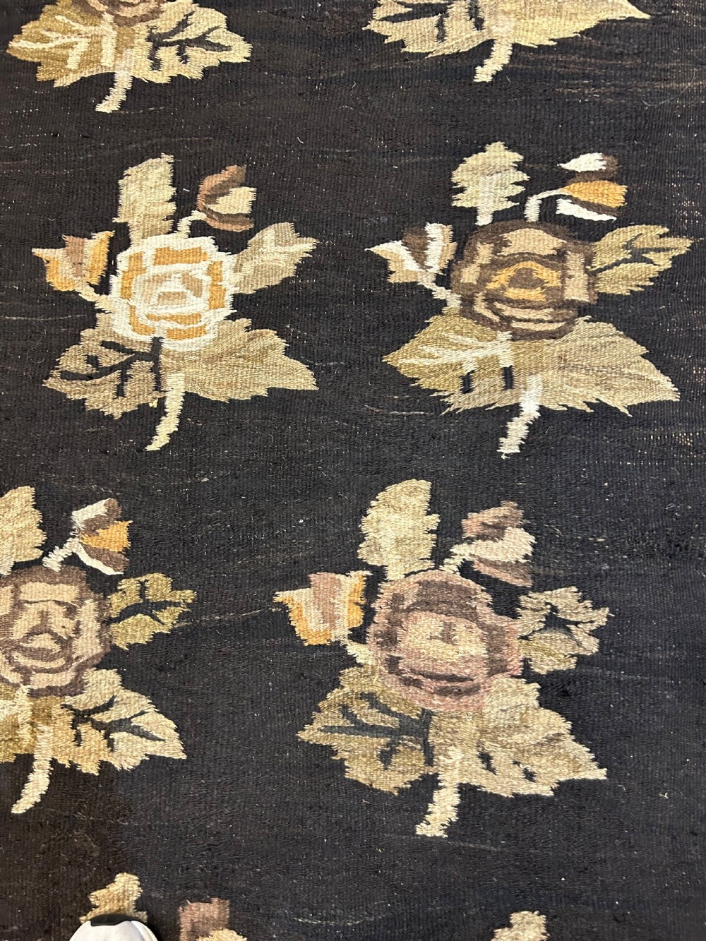 A large flat-woven Ukrainian wool kilim featuring a dark brown background decorated with repeating beige and mustard floral motifs. View V
