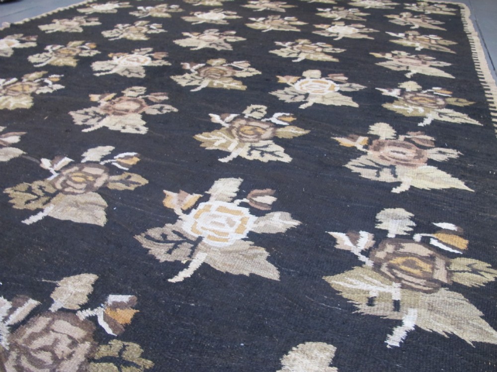 A large flat-woven Ukrainian wool kilim featuring a dark brown background decorated with repeating beige and mustard floral motifs. View XIII