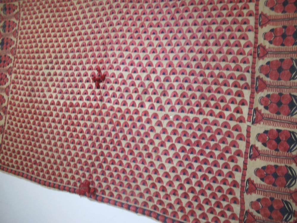 An antique rectangular Sindh embroidered textile featuring a repeating red arched pattern on a beige ground with decorative borders and tassels. View II