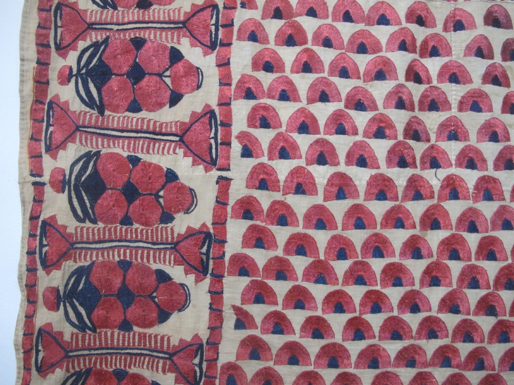 An antique rectangular Sindh embroidered textile featuring a repeating red arched pattern on a beige ground with decorative borders and tassels. View VI