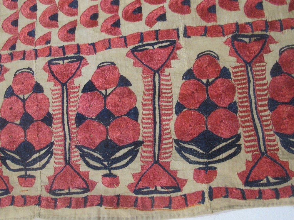 An antique rectangular Sindh embroidered textile featuring a repeating red arched pattern on a beige ground with decorative borders and tassels. View VII