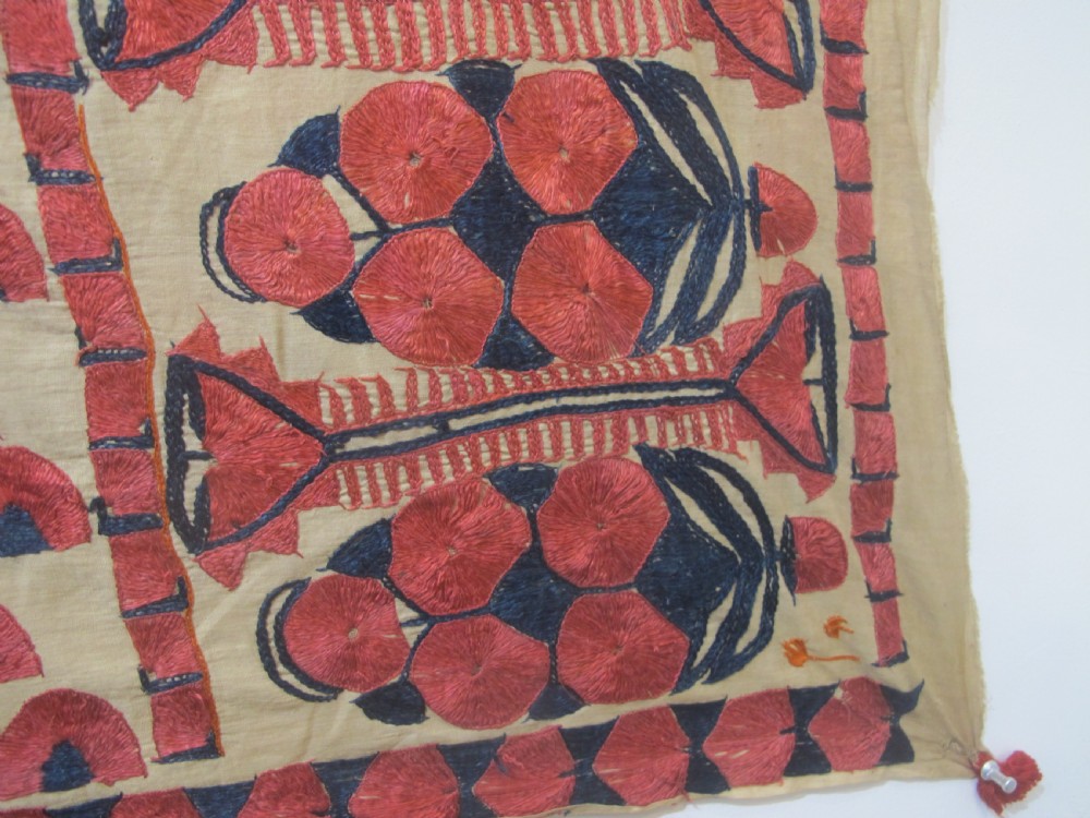 An antique rectangular Sindh embroidered textile featuring a repeating red arched pattern on a beige ground with decorative borders and tassels. View VIII