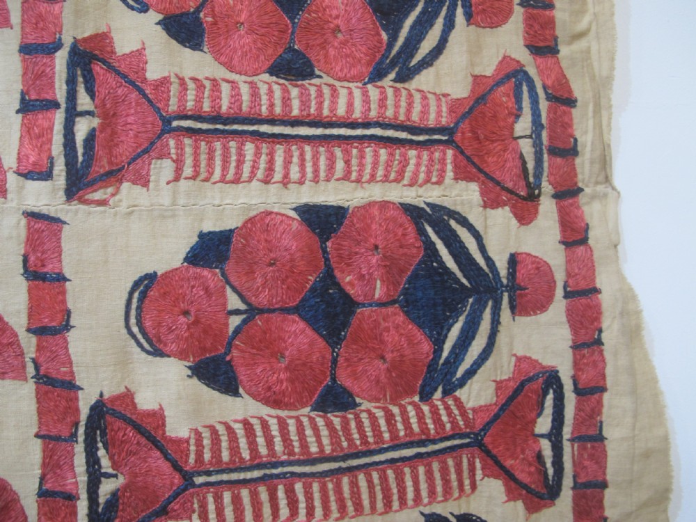 An antique rectangular Sindh embroidered textile featuring a repeating red arched pattern on a beige ground with decorative borders and tassels. View IX