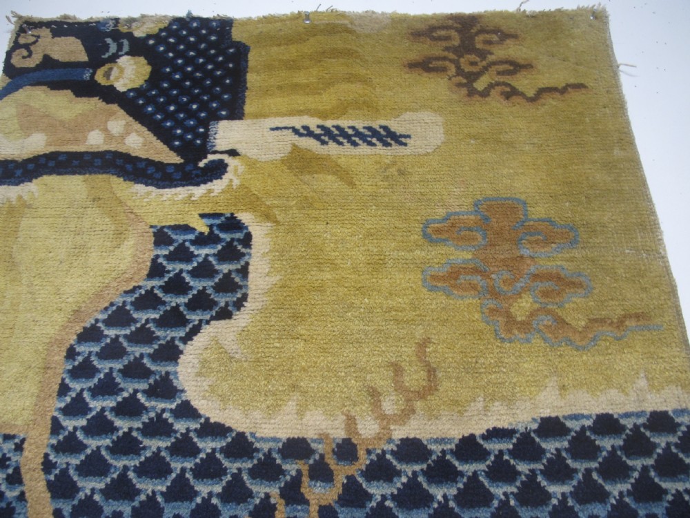 A vertical mid-19th-century Northern Chinese Ningxia pillar rug featuring indigo dragon claws, clouds, and wave motifs woven onto a yellow wool field. View II