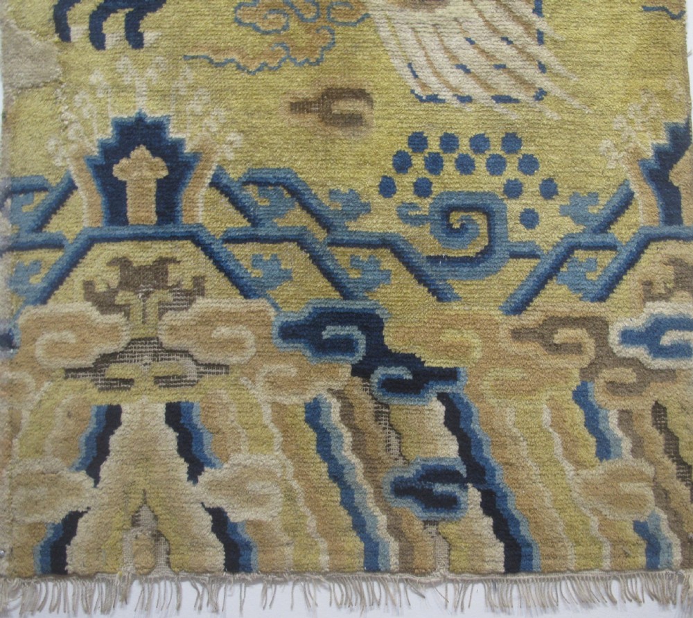 A vertical mid-19th-century Northern Chinese Ningxia pillar rug featuring indigo dragon claws, clouds, and wave motifs woven onto a yellow wool field. View III