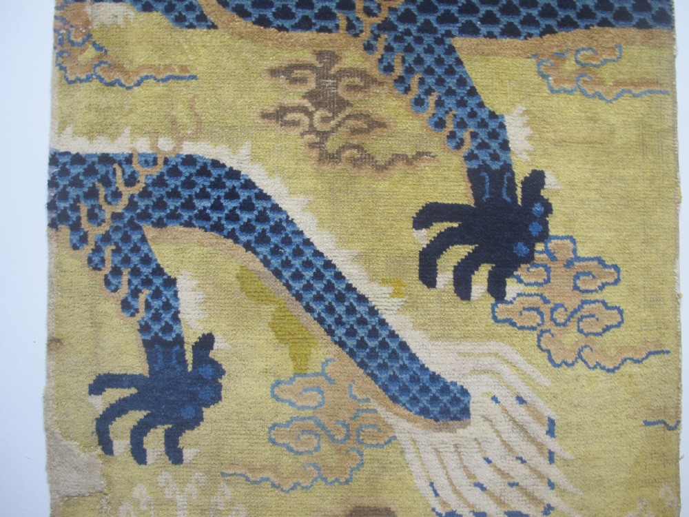 A vertical mid-19th-century Northern Chinese Ningxia pillar rug featuring indigo dragon claws, clouds, and wave motifs woven onto a yellow wool field. View V