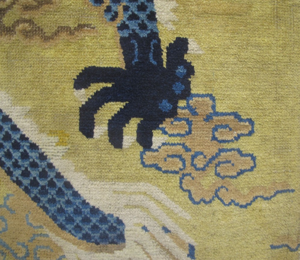 A vertical mid-19th-century Northern Chinese Ningxia pillar rug featuring indigo dragon claws, clouds, and wave motifs woven onto a yellow wool field. View VI