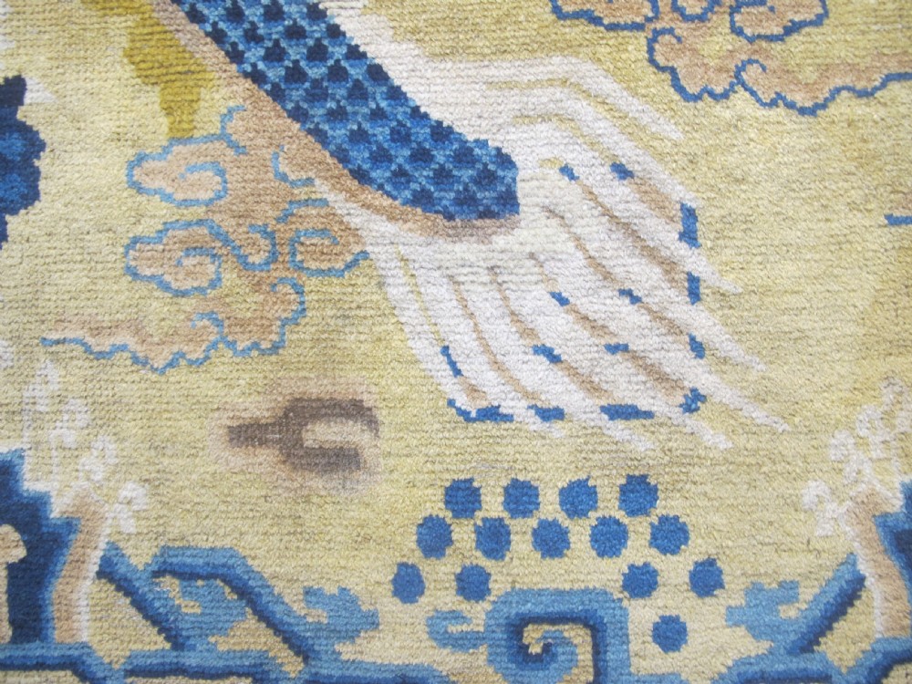 A vertical mid-19th-century Northern Chinese Ningxia pillar rug featuring indigo dragon claws, clouds, and wave motifs woven onto a yellow wool field. View VII