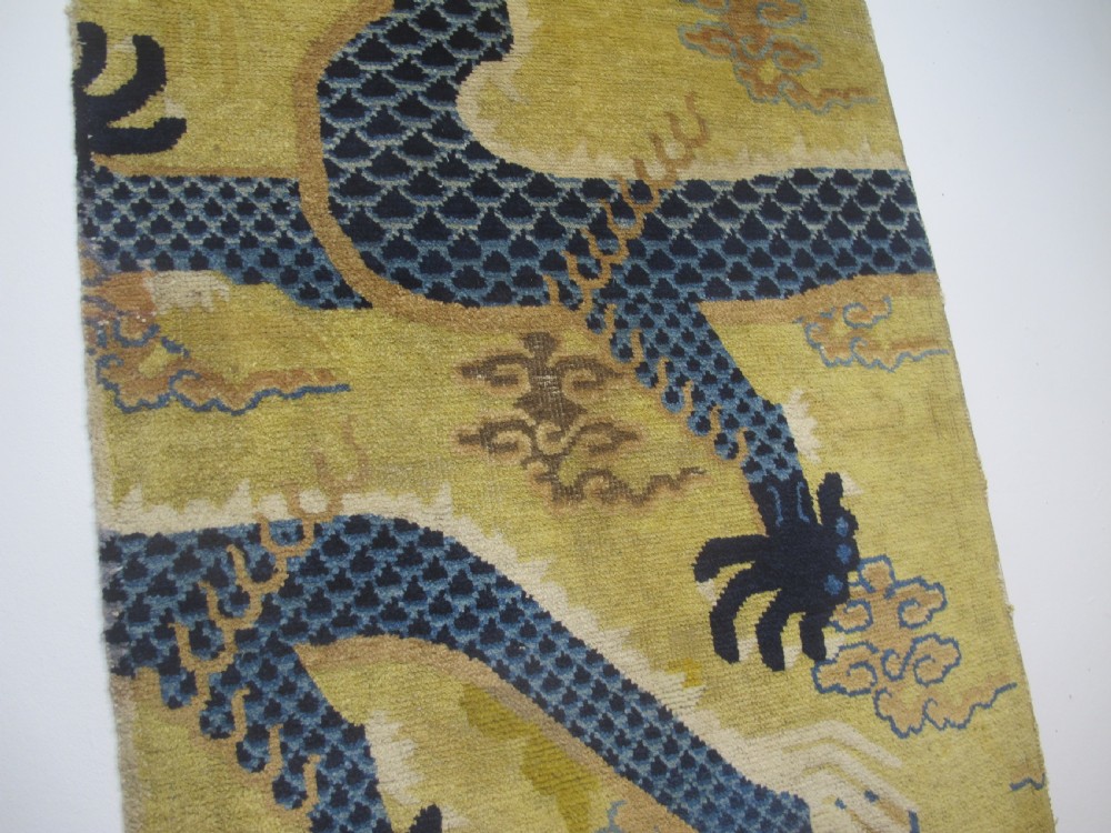 A vertical mid-19th-century Northern Chinese Ningxia pillar rug featuring indigo dragon claws, clouds, and wave motifs woven onto a yellow wool field. View X