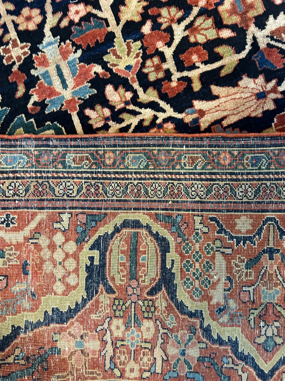 An antique Persian Fereghan carpet featuring an intricate central medallion on a dark navy field surrounded by detailed floral spandrels and terracotta borders. View V