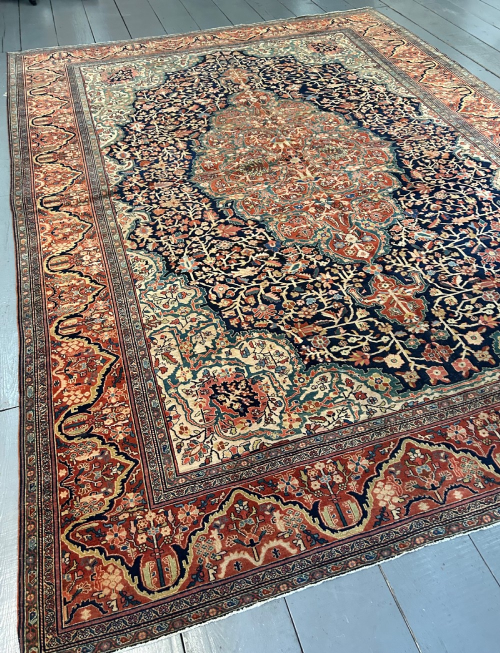 An antique Persian Fereghan carpet featuring an intricate central medallion on a dark navy field surrounded by detailed floral spandrels and terracotta borders. View VII