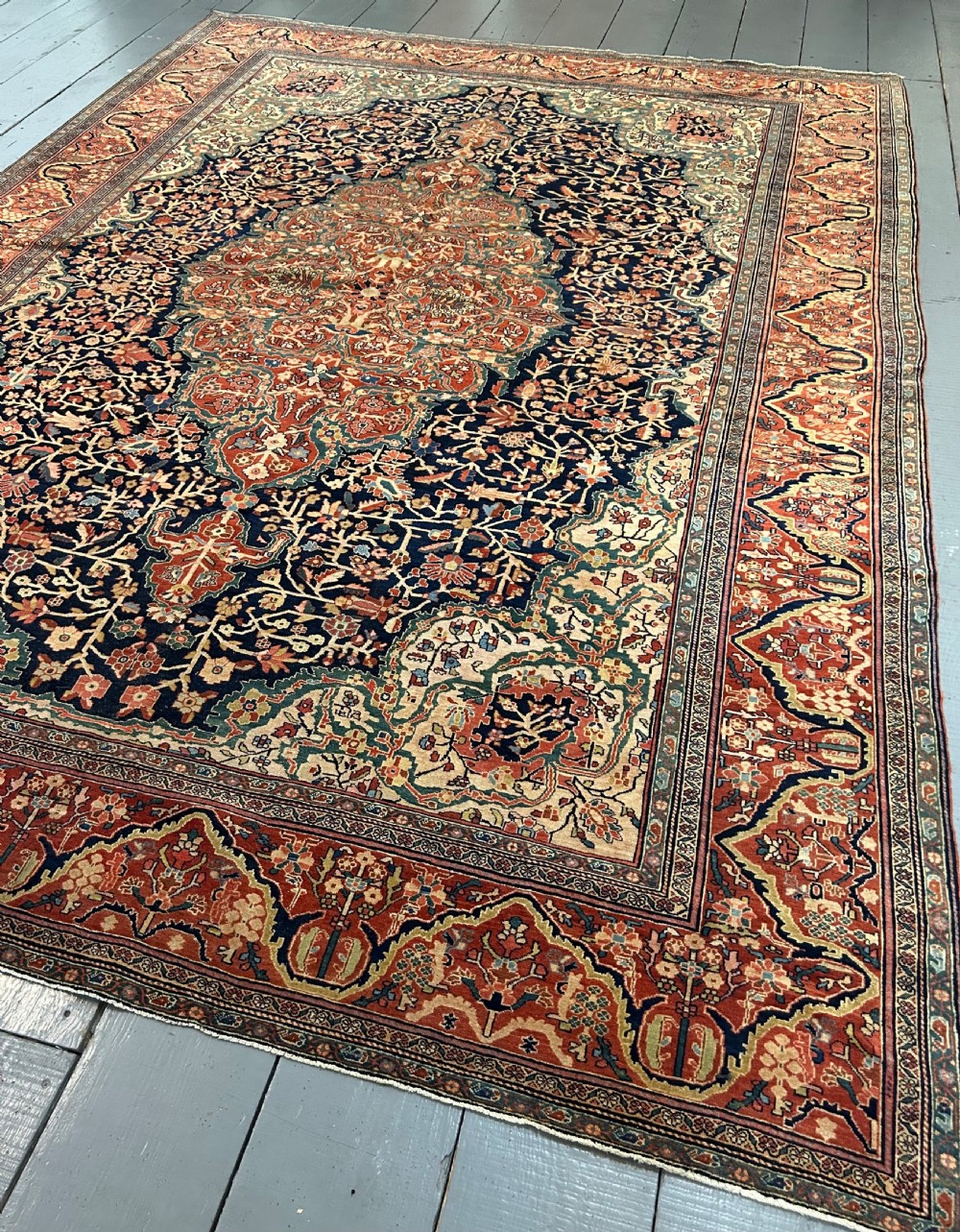 An antique Persian Fereghan carpet featuring an intricate central medallion on a dark navy field surrounded by detailed floral spandrels and terracotta borders. View VIII