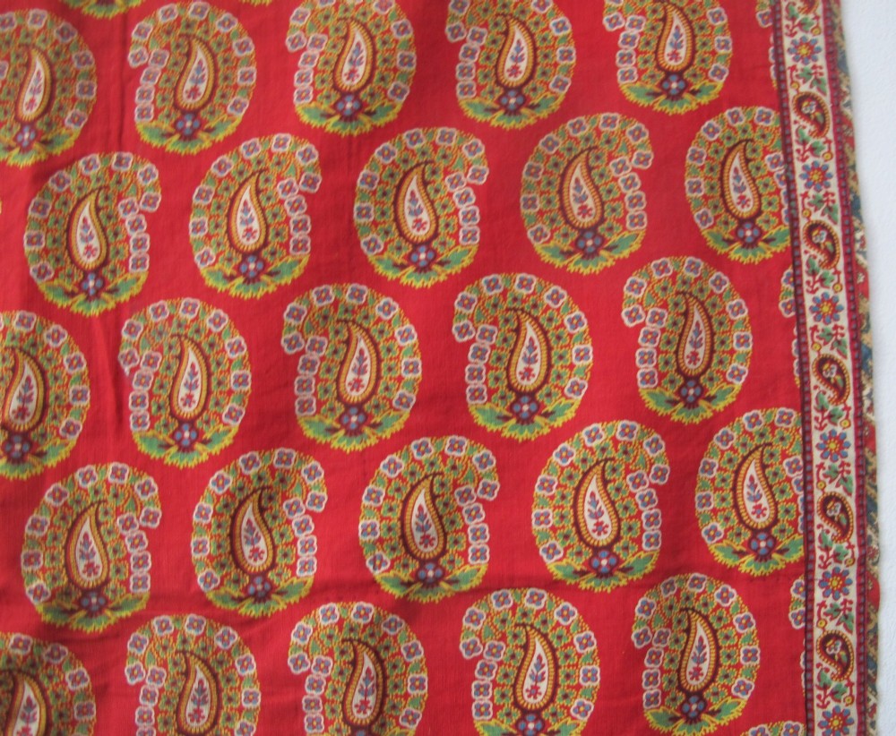 A square late nineteenth-century Indian cotton blockprint panel featuring a dense red, yellow, and green paisley pattern within a thin border. View IV
