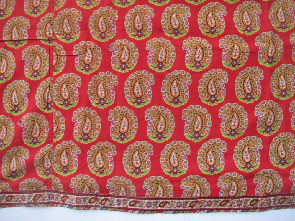 A square late nineteenth-century Indian cotton blockprint panel featuring a dense red, yellow, and green paisley pattern within a thin border. View VI