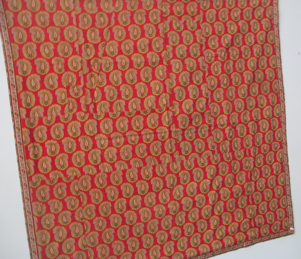 A square late nineteenth-century Indian cotton blockprint panel featuring a dense red, yellow, and green paisley pattern within a thin border. View VII