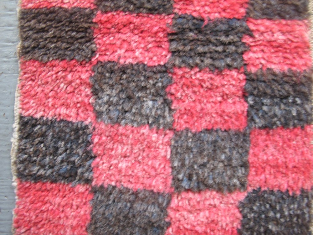 An antique Tibetan wool meditation rug featuring a three-panel chequerboard pattern in pink and dark grey. View VI