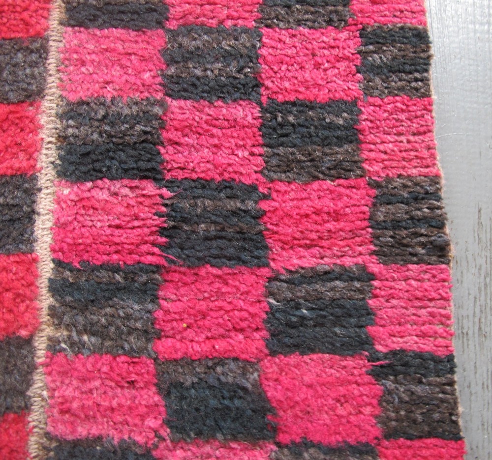 An antique Tibetan wool meditation rug featuring a three-panel chequerboard pattern in pink and dark grey. View VIII