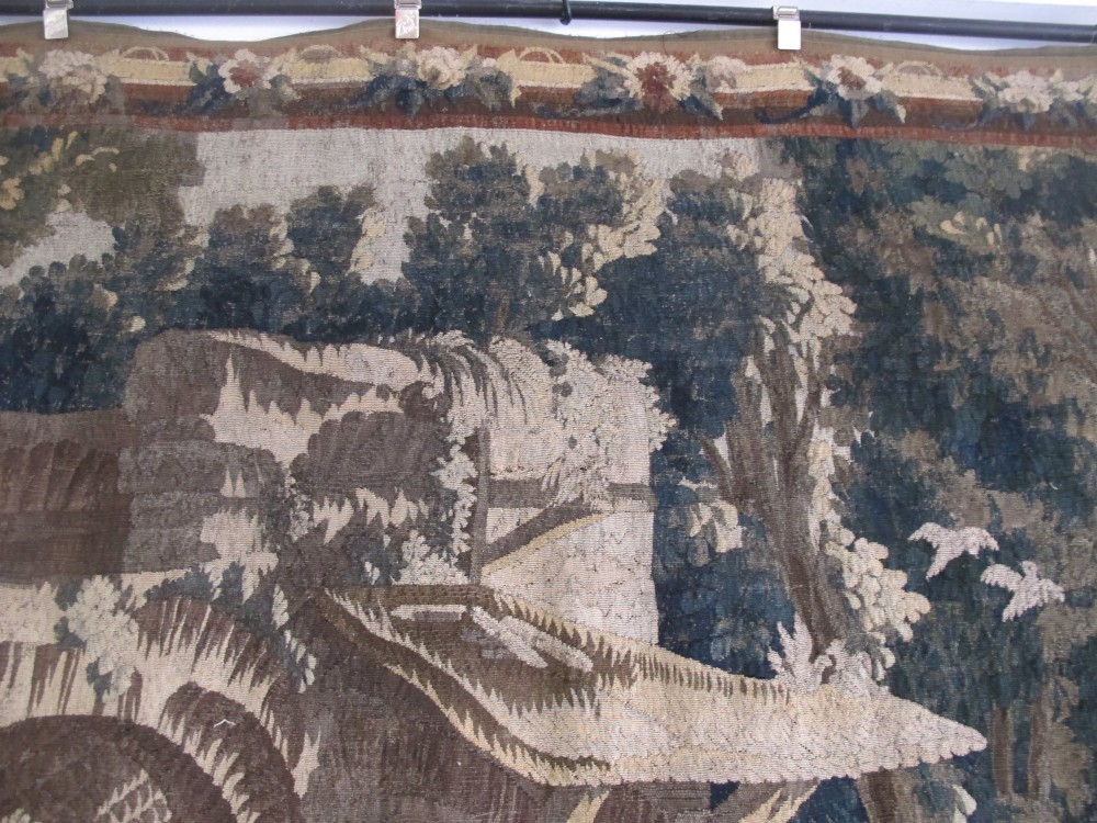 A large late 18th-century French woven tapestry portraying a pastoral scene with dancing figures, a stone building, and leafy trees enclosed within a decorative floral border. View VII