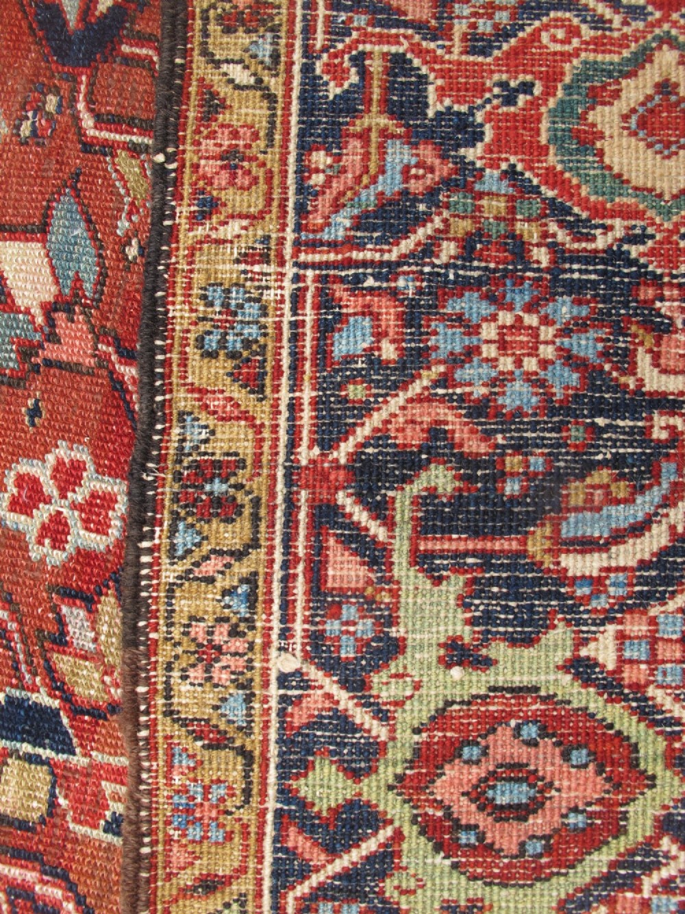 A large late 19th-century Heriz wool carpet featuring an all-over geometric floral motif in terracotta red and navy blue shades. View VIII
