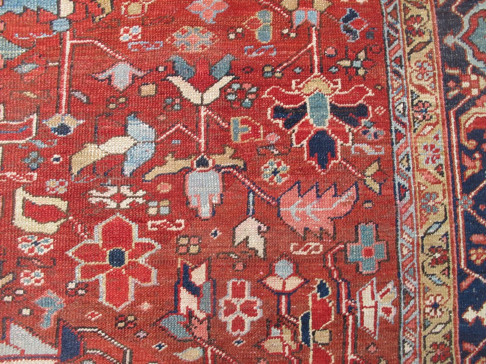 A large late 19th-century Heriz wool carpet featuring an all-over geometric floral motif in terracotta red and navy blue shades. View IX