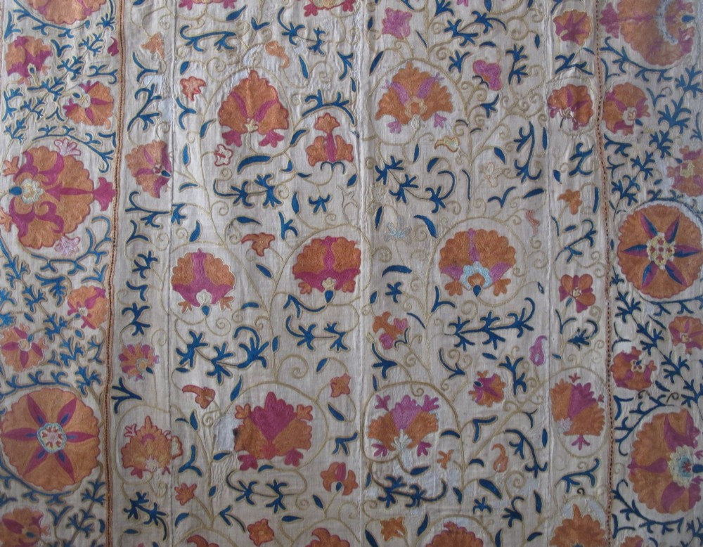 A rectangular hand-embroidered cream cotton textile decorated with orange, pink, and green silk floral roundels and scrolling vine borders. View II