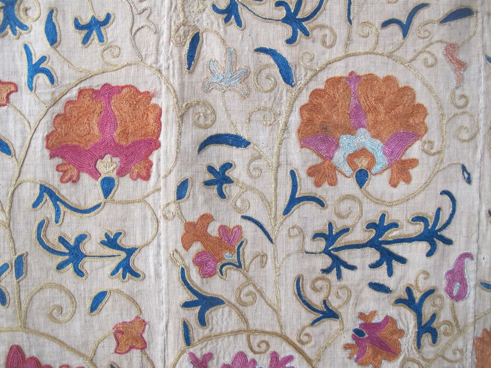 A rectangular hand-embroidered cream cotton textile decorated with orange, pink, and green silk floral roundels and scrolling vine borders. View III