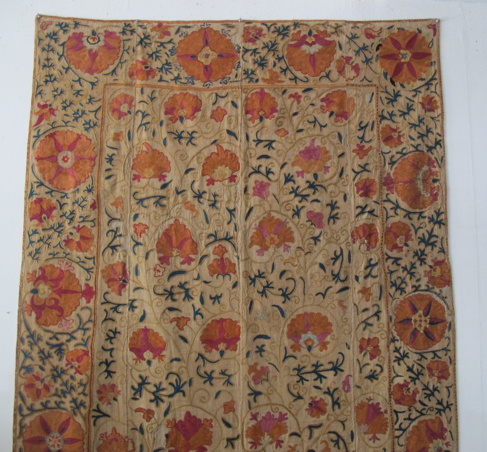 A rectangular hand-embroidered cream cotton textile decorated with orange, pink, and green silk floral roundels and scrolling vine borders. View V