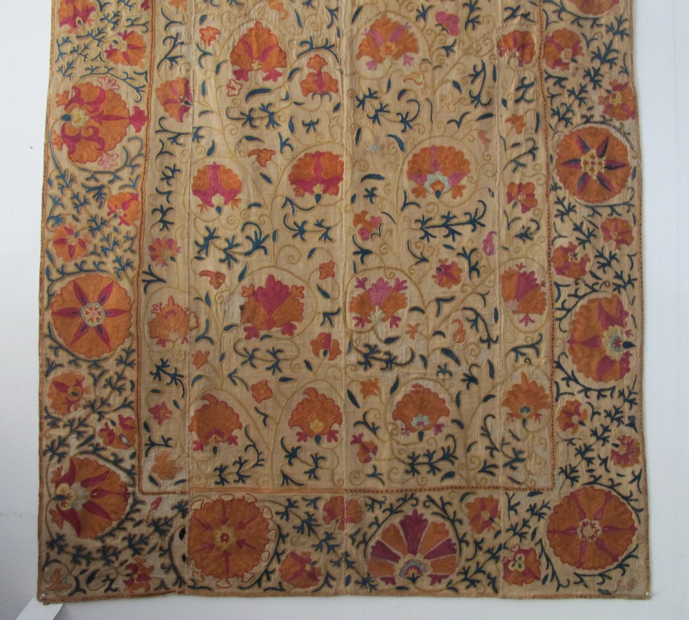 A rectangular hand-embroidered cream cotton textile decorated with orange, pink, and green silk floral roundels and scrolling vine borders. View VI
