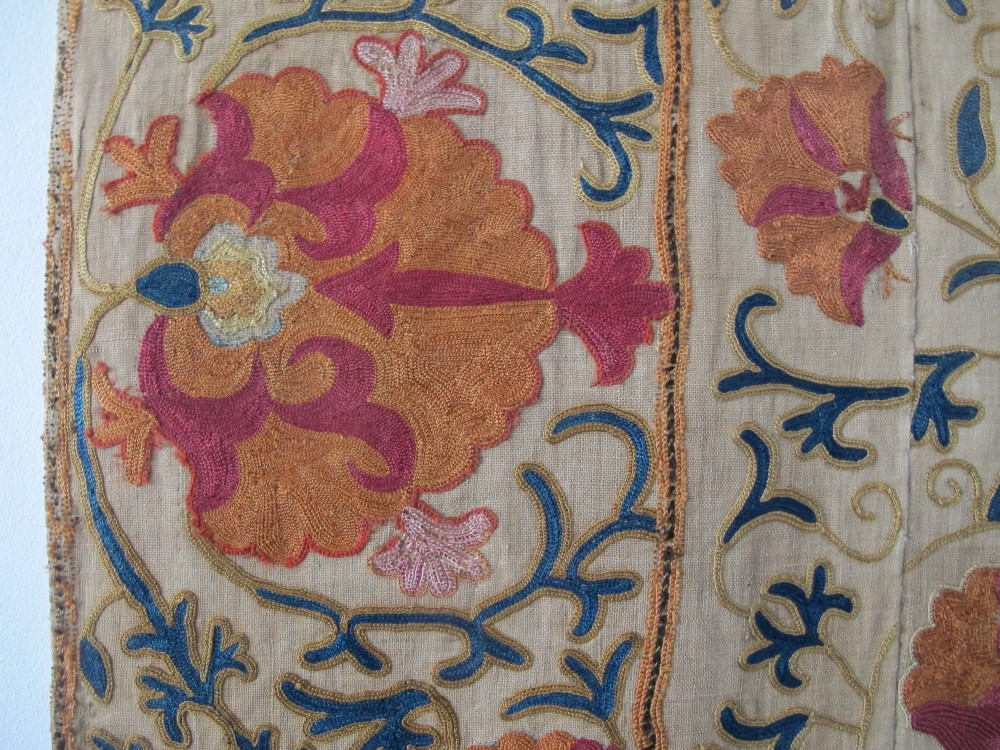 A rectangular hand-embroidered cream cotton textile decorated with orange, pink, and green silk floral roundels and scrolling vine borders. View X