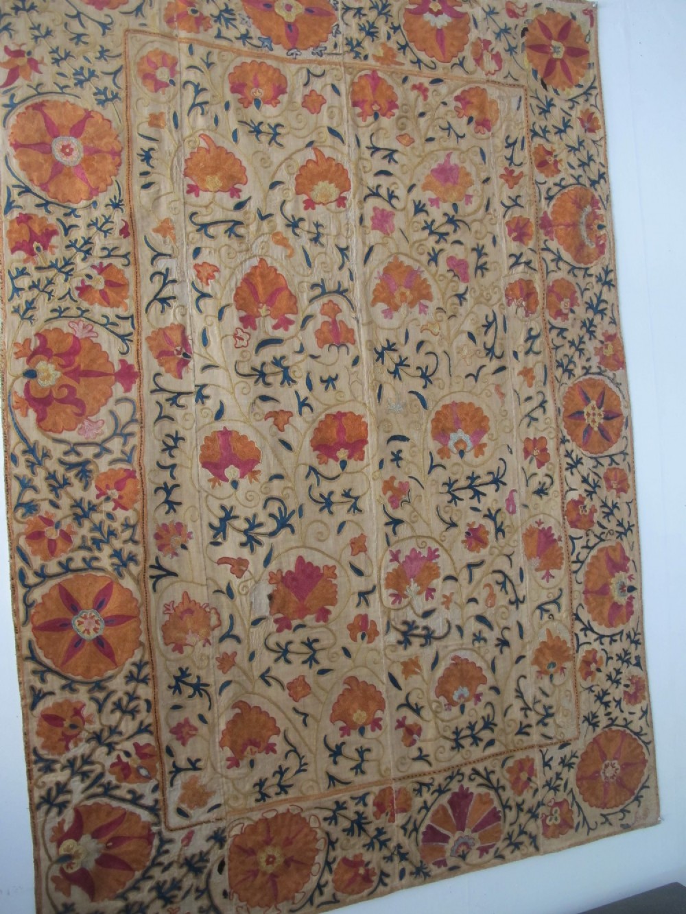 A rectangular hand-embroidered cream cotton textile decorated with orange, pink, and green silk floral roundels and scrolling vine borders. View XIV