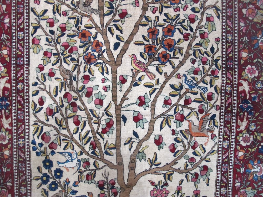 An antique hand-knotted Persian Isfahan wool rug featuring a central cream field with a detailed Tree of Life and bird motifs, framed by a wide deep red floral border. View XII