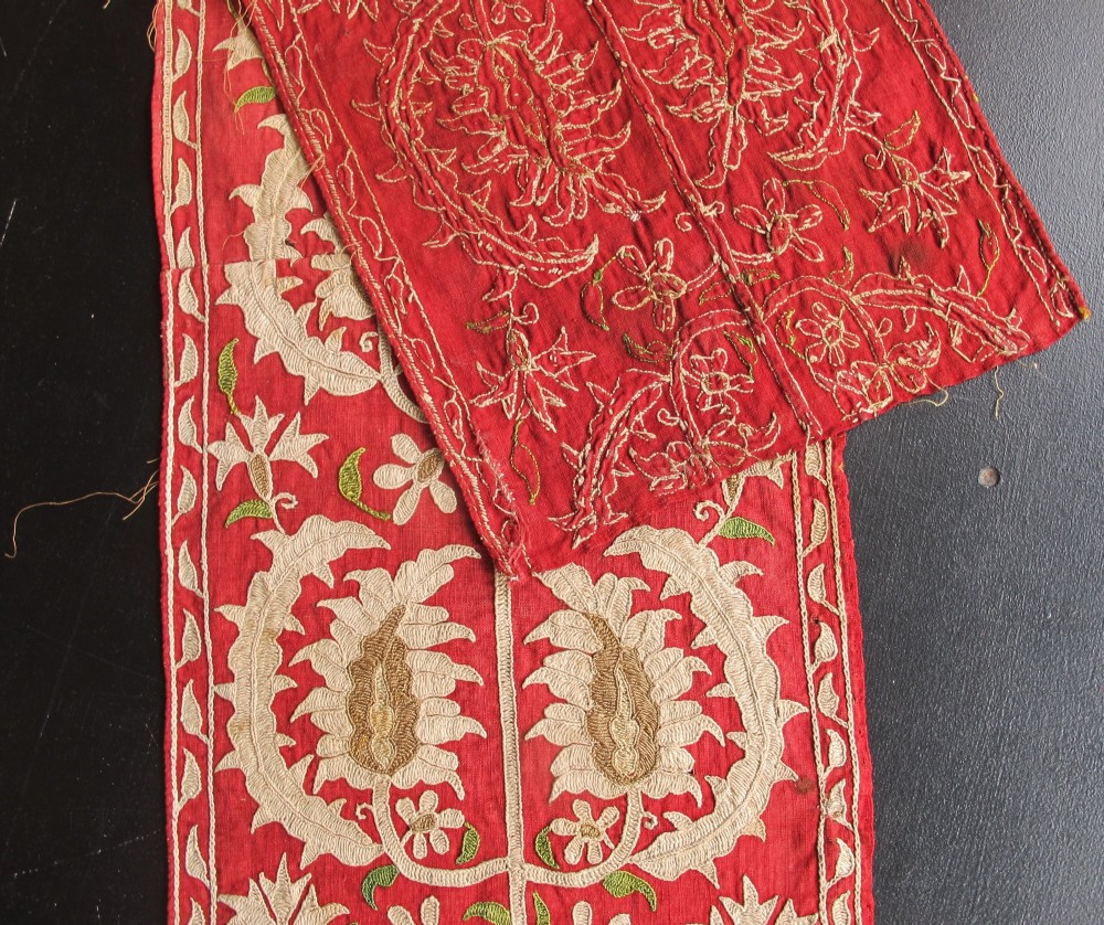 A long, narrow 19th-century Ottoman textile fragment featuring intricate gold botanical embroidery on a vibrant red background. View V
