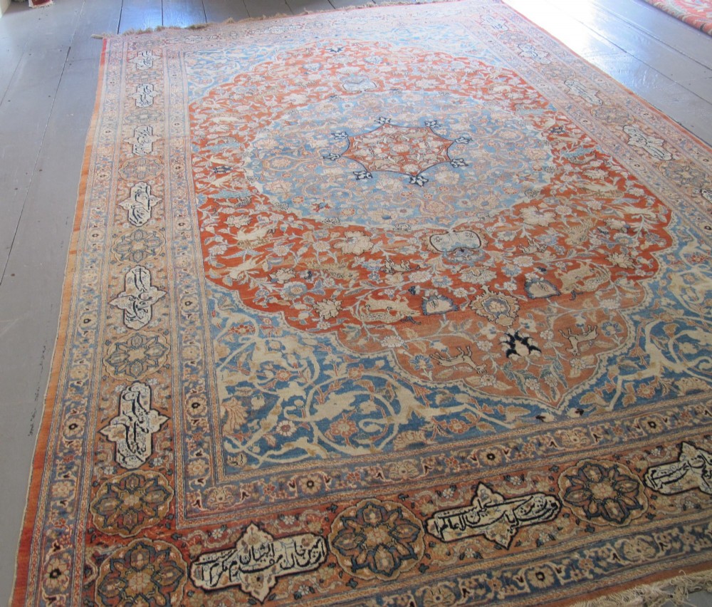An antique Persian Tabriz carpet featuring a central medallion surrounded by floral motifs in terracotta and pale blue with calligraphic border cartouches. View II